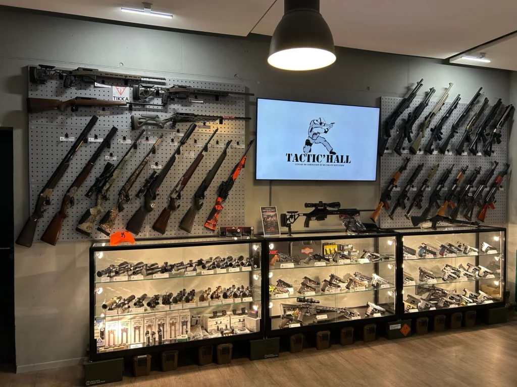 Mur d'armes longues et vitrines d'optiques et de pistolets de l'armurerie Tactic'Hall